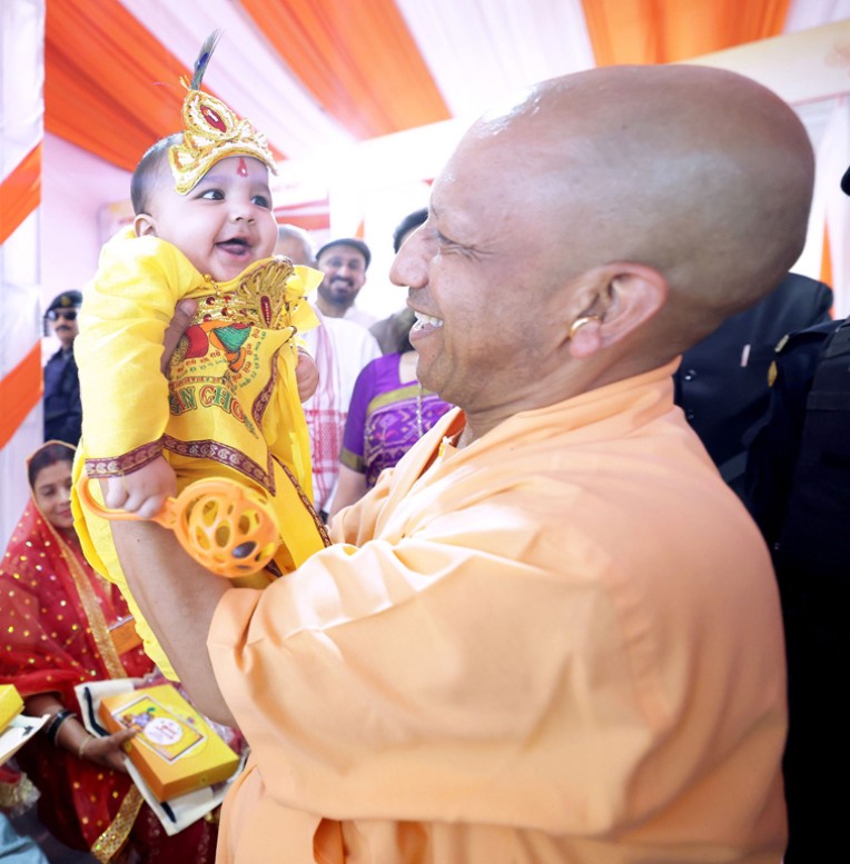 नन्हे कृष्ण को दुलराते मुख्यमंत्री योगी