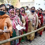 मतदान केंद्र पर कतार में खड़े मतदाता
