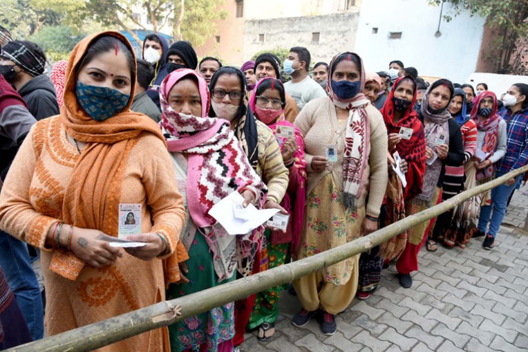 मतदान केंद्र पर कतार में खड़े मतदाता